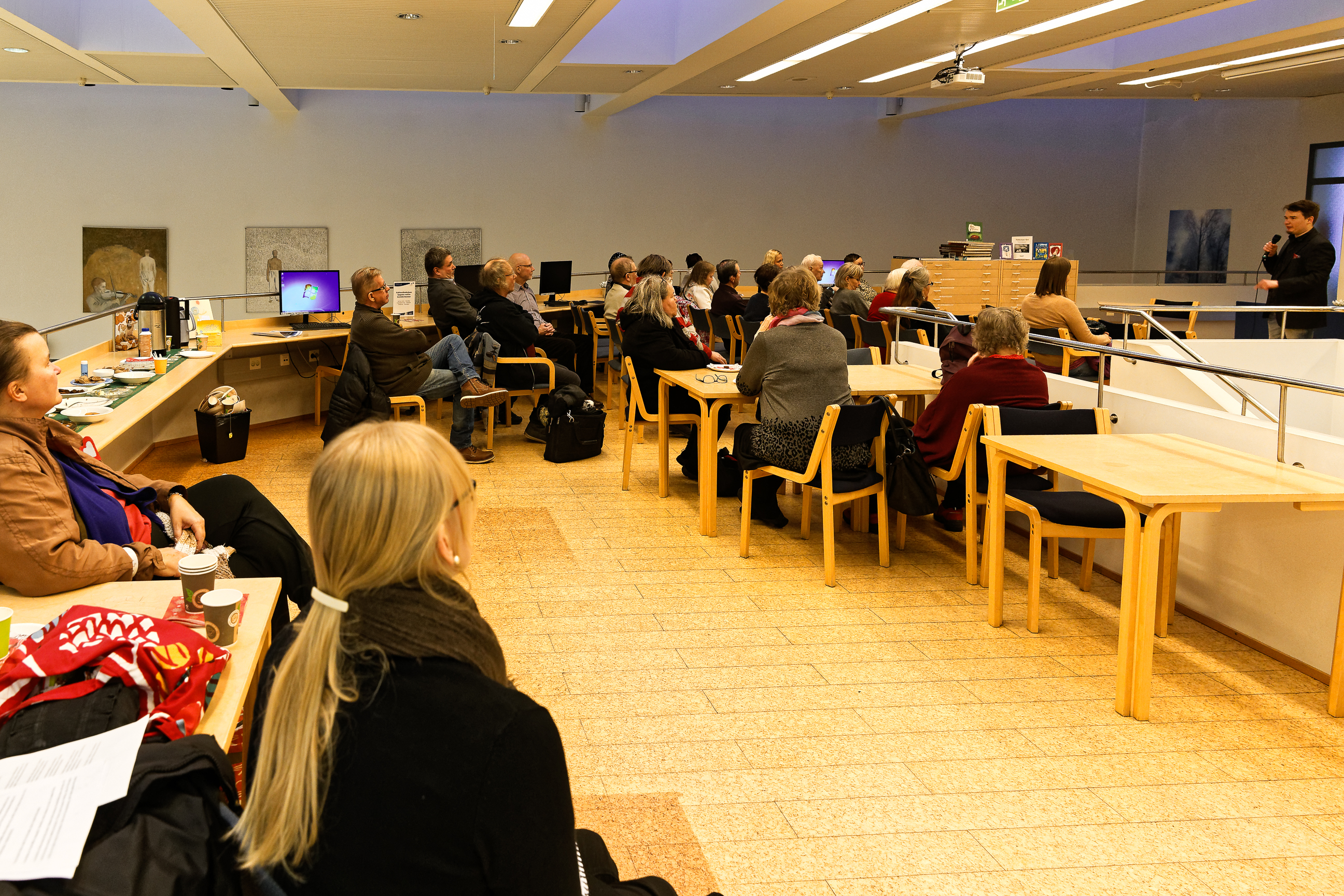 Audience listening to author Antti Heikkinen’s energetic performance.